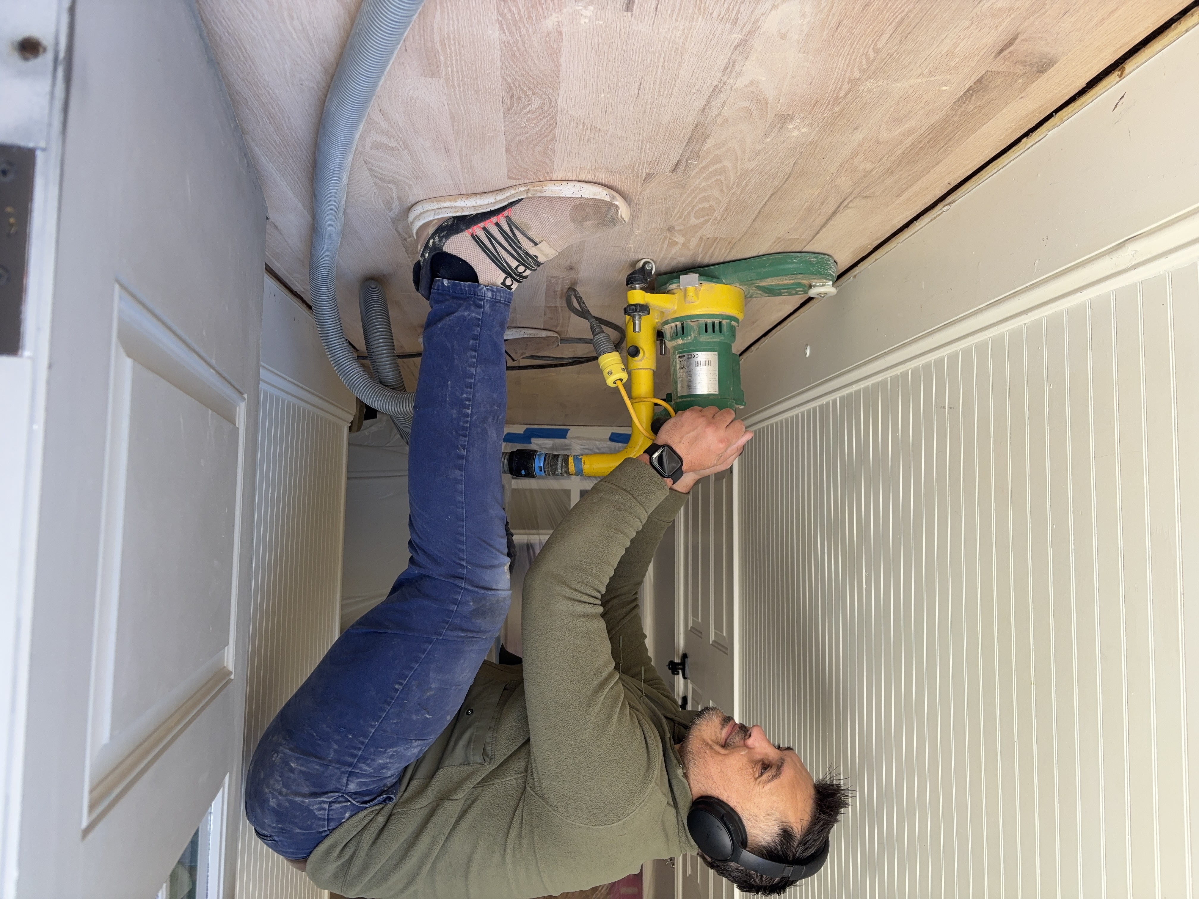 Floor refinishing contractor sanding hardwood floors in Alpharetta home